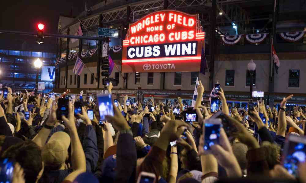 Chicago fans celebrate the Chicago Cubs 8-7 victory over the Cleveland Indians in Cleveland in 10th inning in game seven of the 2016 World Series, outside Wrigley Field in Chicago, Illinois early on November 3, 2016. Ending America's longest sports title drought in dramatic fashion, the Chicago Cubs captured their first World Series since 1908 by defeating the Cleveland Indians 8-7 in a 10-inning thriller that concluded early on November 3. / AFP PHOTO / Tasos KatopodisTASOS KATOPODIS/AFP/Getty Images ORIG FILE ID: AFP_HQ3TZ